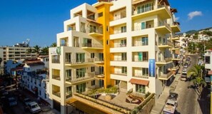 A multi-story hotel with balconies, a central courtyard, and a view of the surrounding urban area.
