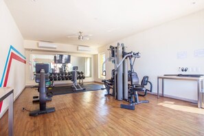 A gym with exercise equipment, a treadmill, and a mirror.