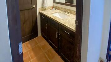A bathroom with a sink, mirror, and dark wooden cabinets.
