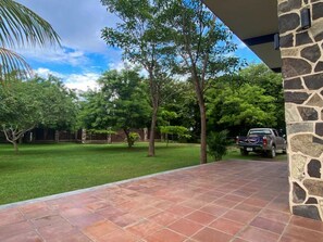 A patio with stone walls and a vehicle parked in the background.