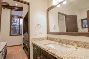 Un baño con lavabo, espejo y ventana.