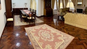 A spacious living area with a dining table, chairs, a sofa, and a fireplace. - DMCharme (Ponta Delgada)