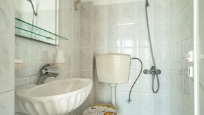 A bathroom with a white sink, toilet, and shower. - Room “Angela sea view 7” with Sea View, Wi-Fi, and Air Conditioning (kefalonia)