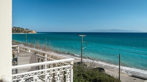 A balcony with a view of the sea, a power pole, and a distant coastline. - Room “Angela partial sea view 6” with sea view, Wi-Fi, and air conditioning (kefalonia)