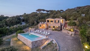 A stone villa with a pool, outdoor seating, and a staircase leading to the upper levels. - Villa 'Coral Bay' with Sea View, Wi-Fi and Air Conditioning (Alghero)