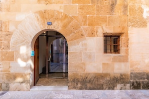 Une entrée en pierre, avec une porte, une fenêtre et une enseigne indiquant le numéro de la pièce : 10.