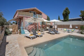 Un bâtiment à deux étages doté d’une piscine, d’un espace extérieur aménagé et d’un escalier menant à l’étage supérieur.