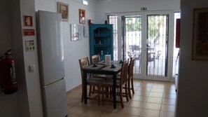 A dining area with a table and chairs, a blue cabinet, and a door leading outside.