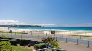Eine Küstenpromenade mit Blick auf Strand und Meer.