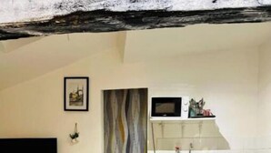 A compact living space with a kitchenette, a flat-screen TV, and a small dining area. - renovated studio 30m2 5 min from the train station (Bordeaux)