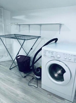 Convenient laundry facilities with a washing machine and drying rack.
