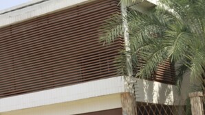 A building with a brown facade, a metal fence, and a palm tree. - Residence Jireh  (Abidjan)