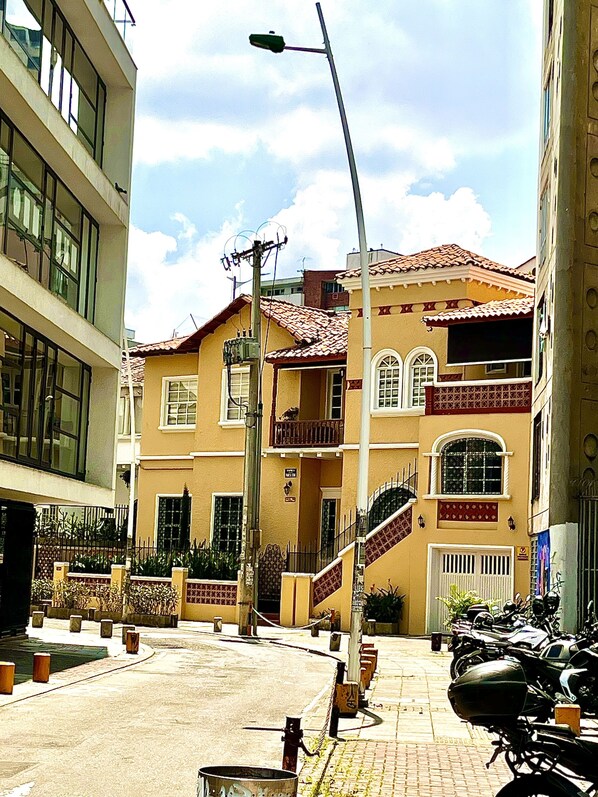 Un edificio con techo de tejas rojas, un balcón y una escalera que conduce a la entrada.