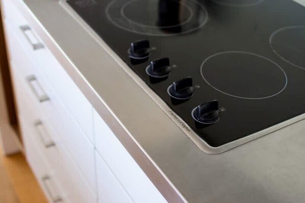A kitchen with a black stovetop and four burners.
