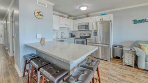 A modern kitchen with a central island, stainless steel appliances, and a seating area with stools.