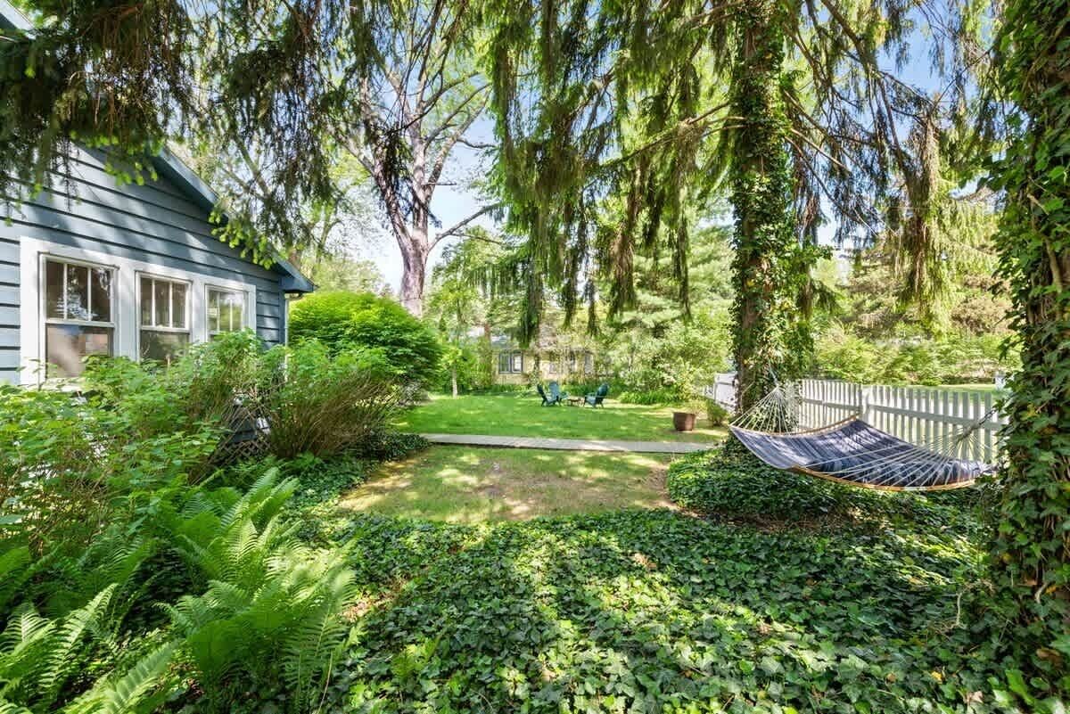 A house with a garden, a hammock, and a lawn.