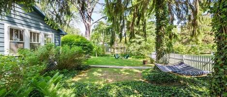 A house with a garden, a hammock, and a lawn.
