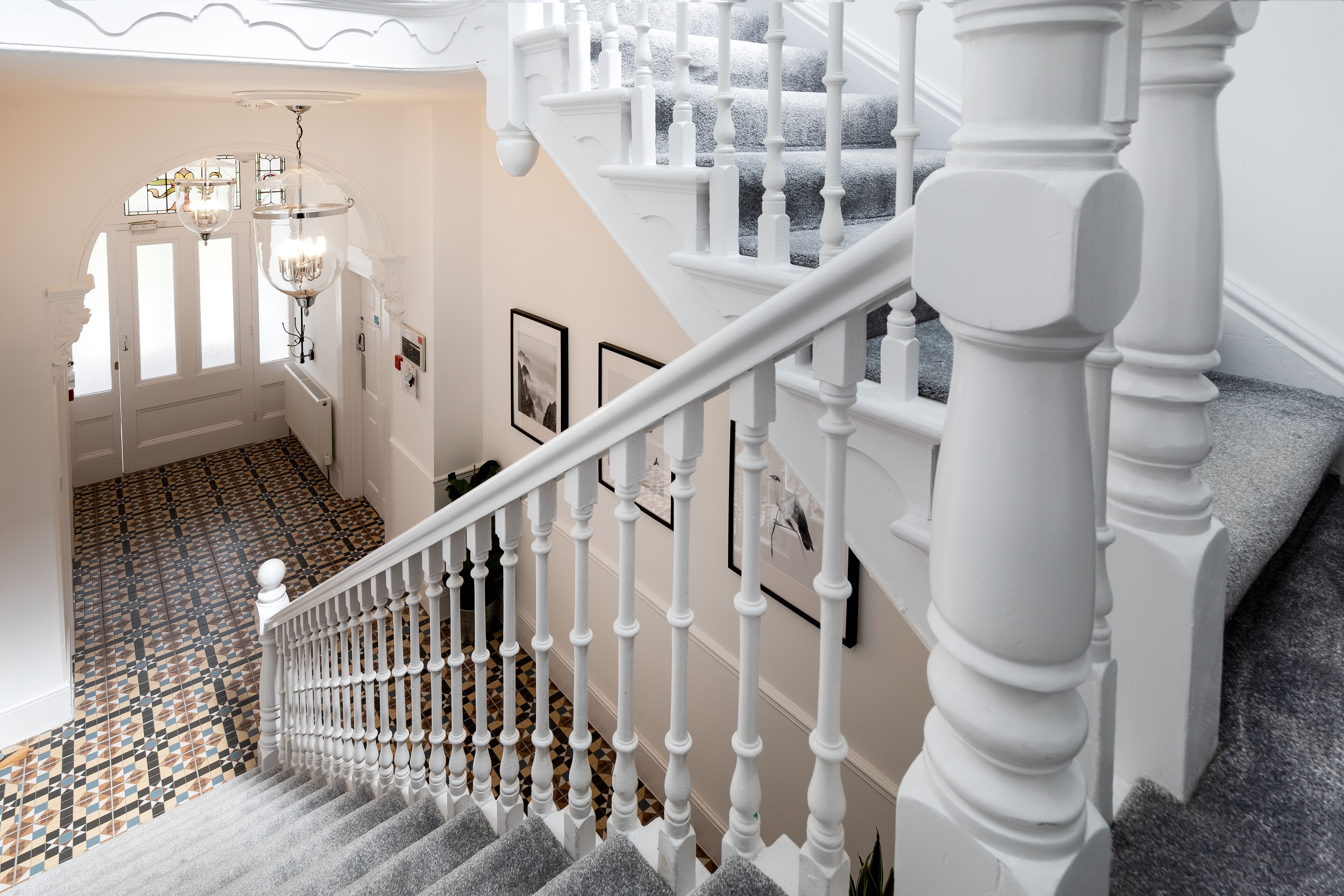 A staircase with white balusters and a patterned floor.