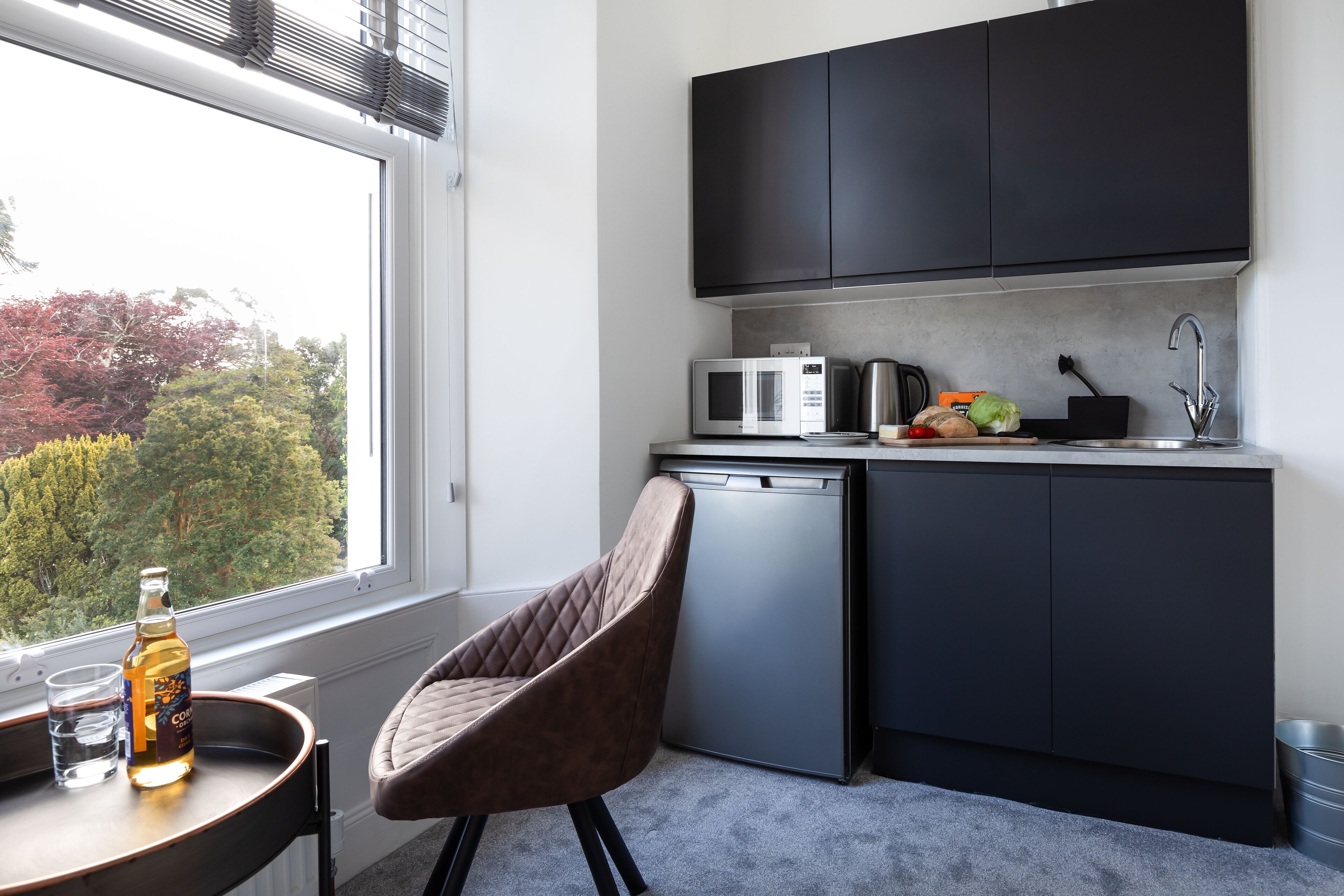 A modern kitchen with dark cabinets, a microwave, and a dishwasher.
