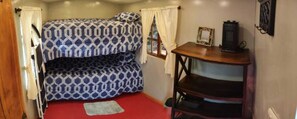 A bunk bed with patterned bedding, a small table with a lantern, and a window with curtains. - VIP Villa with Jacuzzi and Turkish Bath, Sleeps 20, 3 Bedrooms, 15 Minutes from Downtown (CUENCA)