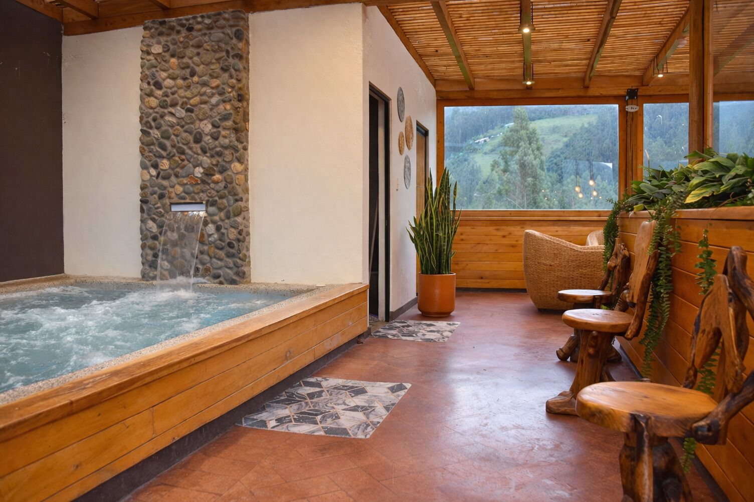 Ein Wellnessbereich mit Whirlpool, Holzmöbeln und einer Steinwand.