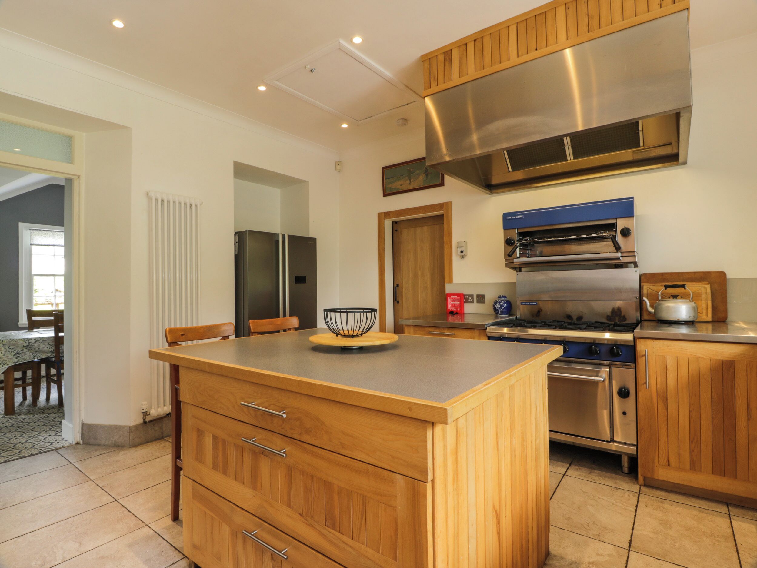 Una cocina moderna con armarios de madera, electrodomésticos de acero inoxidable y una isla central.