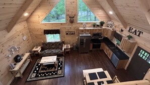 Ein gemütliches Blockhaus mit Schlafzimmer im Zwischengeschoss, Essbereich und Küche.