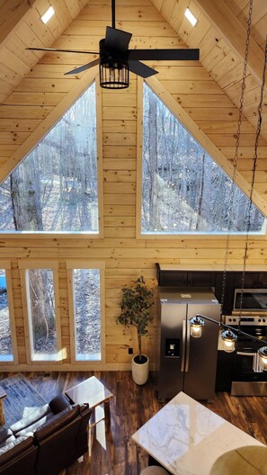 Una cocina amplia con un refrigerador grande, estufa y comedor con mesa y sillas.