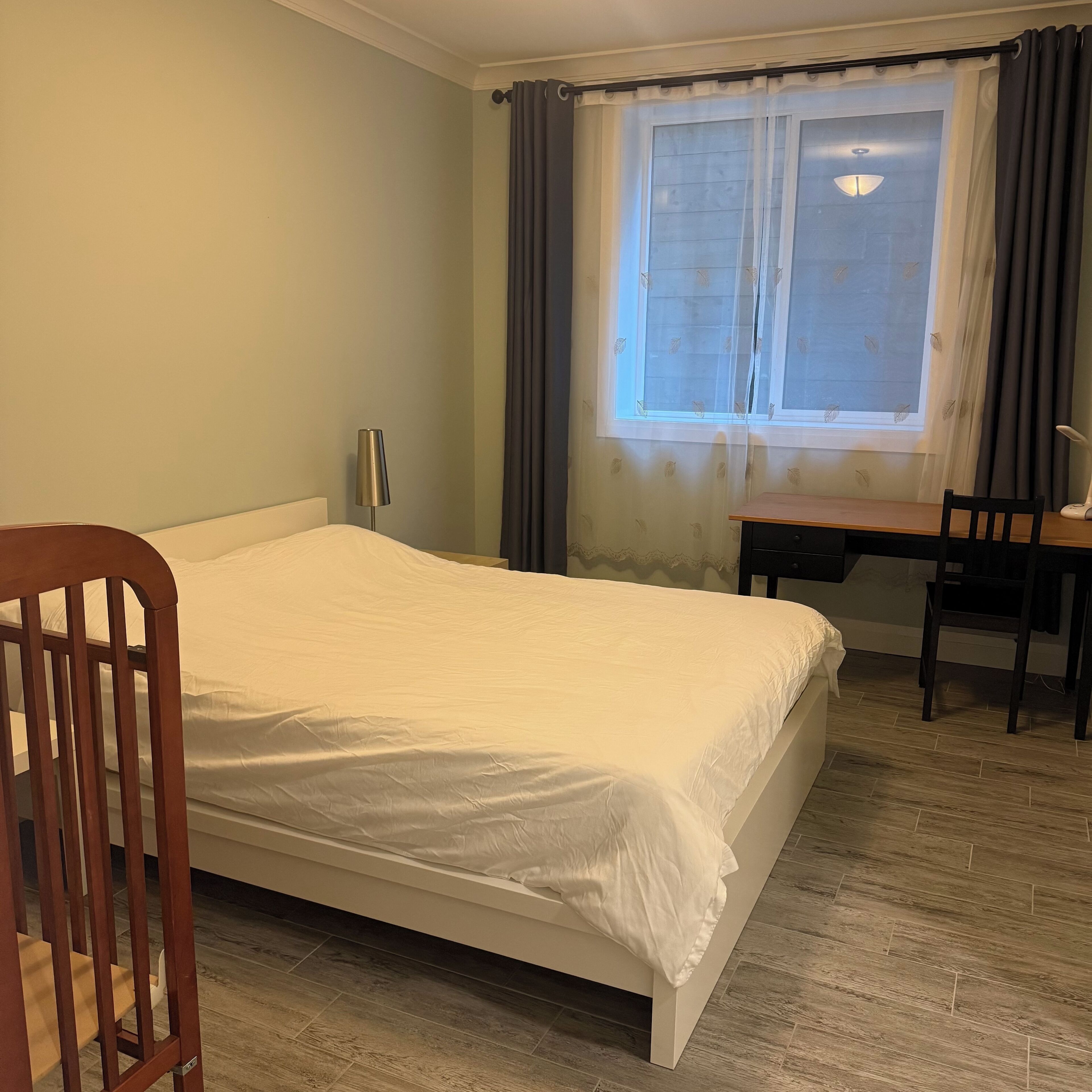 Un dormitorio con cama, escritorio y silla.