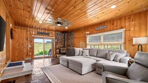 A cozy living room with a sectional sofa, a fireplace, and a view of the outdoors.
