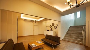 Ein geräumiges Wohnzimmer mit einer Couch, einem Couchtisch und einer Treppe, die zu einer oberen Etage führt.