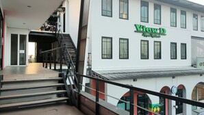 Ein Gebäude mit einer Treppe, die zu einem Balkon führt, einem Schild mit der Aufschrift "View D Apartments Residence" und einer Flagge mit einem Friedenssymbol.