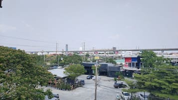 A commercial area with multiple buildings, a parking lot, and a bridge in the background.