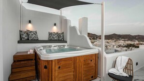 A modern bathroom with a hot tub, wooden cabinets, and a view of a coastal town. - K Town Suites Naxos Penthouse Apartment (Naxos)