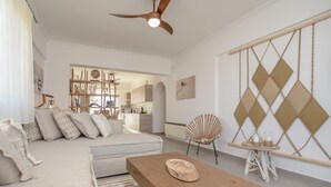 Un saló modern amb un sofà, una taula de centre de fusta i un panell decoratiu a la paret.