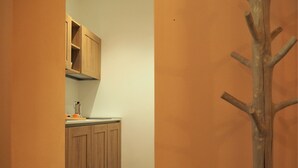A narrow hallway with wooden cabinets and a wooden ladder leaning against the wall. - Magnolia Apartment (Colombare)