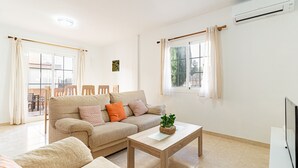 Un salon avec un canapé, une table basse et un téléviseur.