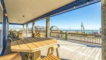 Enjoy a tranquil ocean view from this covered outdoor space with a large table and comfortable benches.