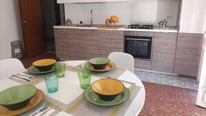 Une cuisine moderne avec une table à manger dressée pour quatre personnes, agrémentée d’assiettes vertes et jaunes.