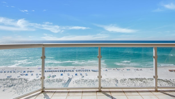 A balcony with a view of a beach and ocean.