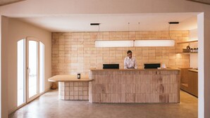 A modern kitchen with a wooden island counter, pendant lights, and a large window.