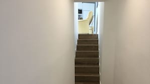 A narrow staircase with wooden steps leading to a landing.