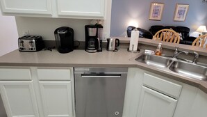 A modern kitchen with white cabinets, a dishwasher, a coffee maker, and a toaster. - 4BR Disney Villa w/ Private Pool - Lake Berkley Resort (Kissimmee)