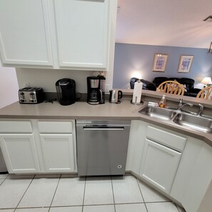 A modern kitchen with white cabinets, a dishwasher, a coffee maker, and a toaster. - 4BR Disney Villa w/ Private Pool - Lake Berkley Resort (Kissimmee)