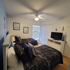 A bedroom with a bed, a TV, a ceiling fan, and artwork on the walls. - 4BR Disney Villa w/ Private Pool - Lake Berkley Resort (Kissimmee)