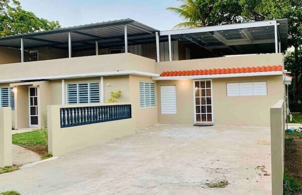 Un bâtiment à deux étages, doté d’un toit plat, de grandes fenêtres et d’un patio couvert.