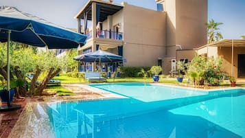 Piscine extérieure, parasols de plage, chaises longues