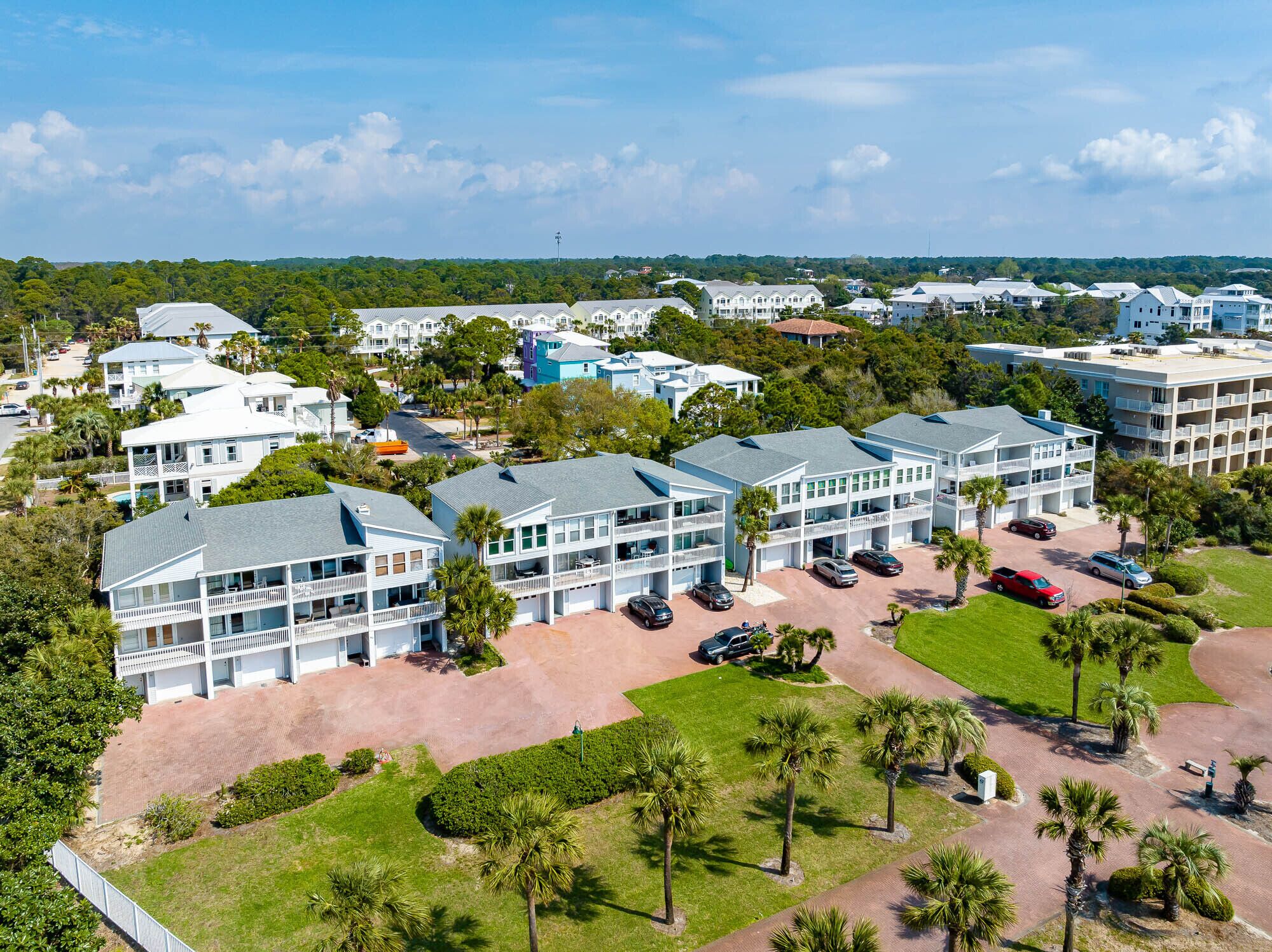 A large hotel complex with multiple buildings, a parking area, and surrounding greenery.