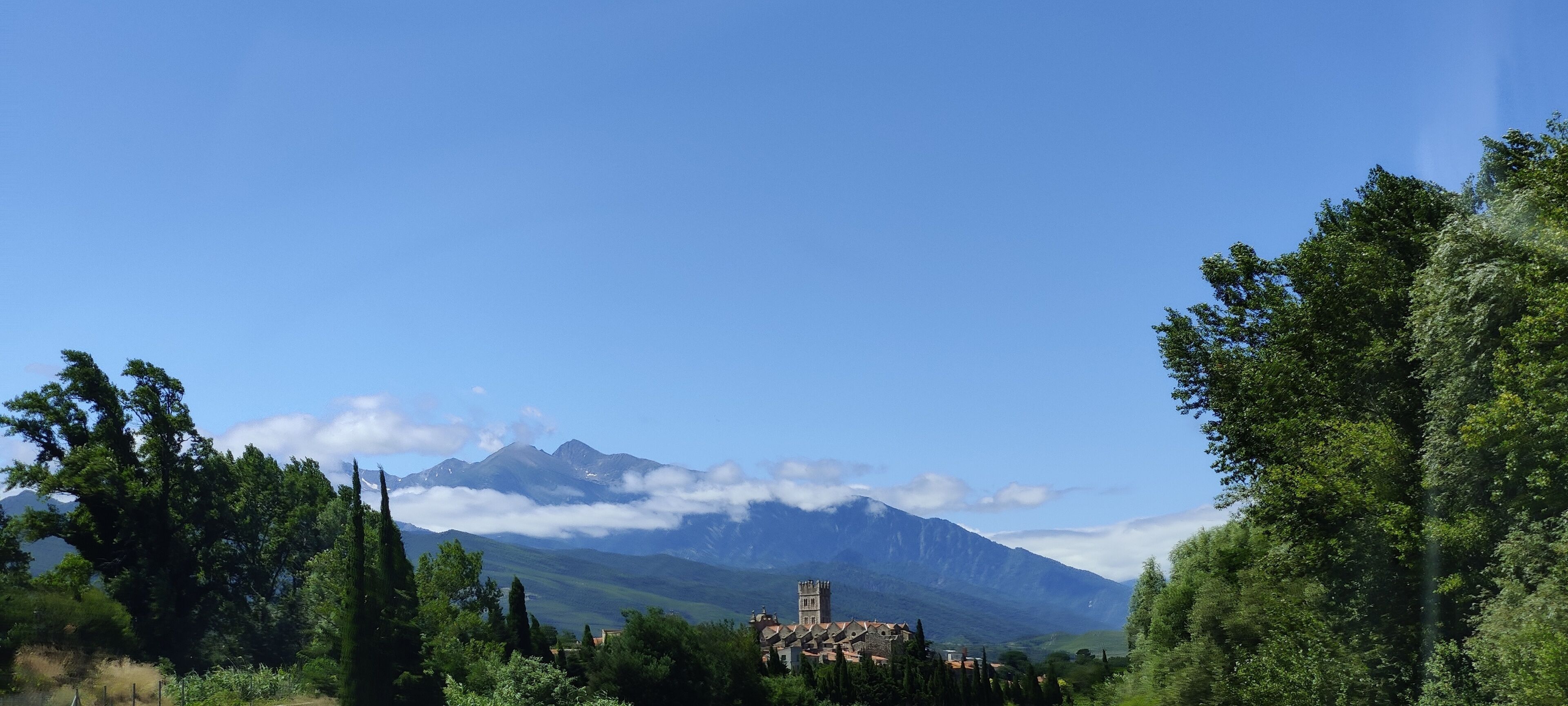A mountainous landscape with a church and surrounding greenery.