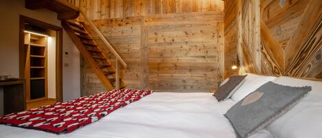 Un intérieur en bois comprenant un lit, un escalier et un mur en bois.